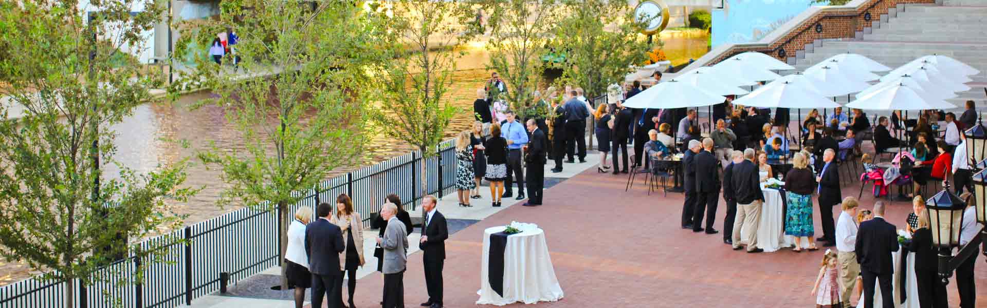 Cocktail hour on the Stardust Terrace, people standing and sitting around and at tables. Central Canal in background.