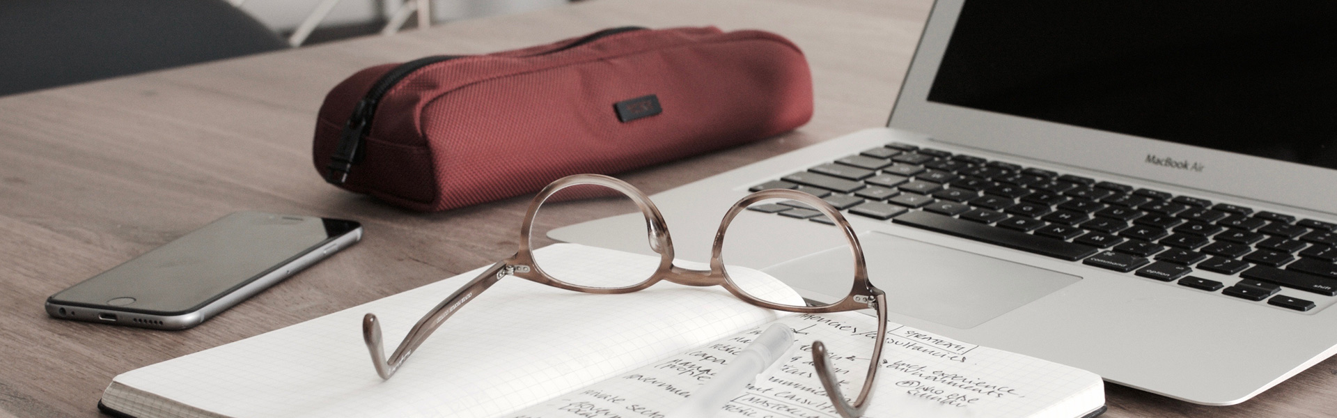 Photo of computer, glasses, notepad